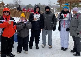 Winter Special Olympics athletes and coaches pose for picture outside at Winter Games